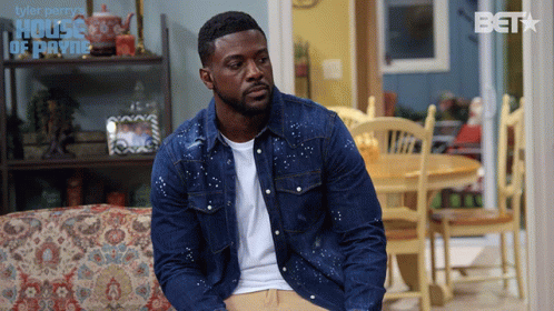 Man In Denim Jacket On Couch In Front Of House Of Payne Sign GIF