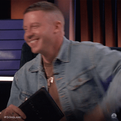 Man In Denim Jacket Smiling Holding Book With Songland GIF
