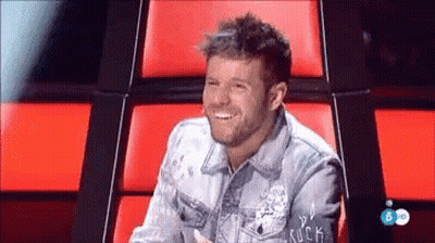 Man in Denim Jacket Smiling in Red Chair