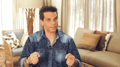 Man In Denim Shirt Sitting By Couch GIF