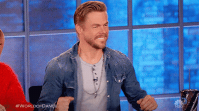 Man In Denim Shirt Sitting By Window Arms Up GIF