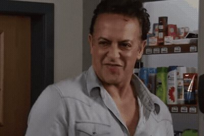 Man in Denim Shirt Standing in Front of Shampoo Shelf