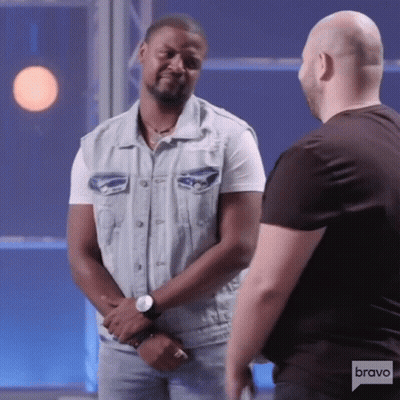 Man In Denim Vest Talking To Man In Black Shirt On Bravo GIF