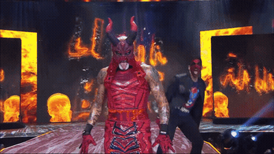 Man In Devil Costume On Stage With Flames GIF