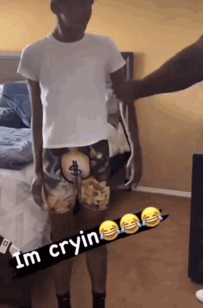 Man In Dollar Sign Shorts Beside Bed GIF