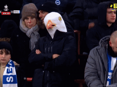 Man In Eagle Mask Giving Peace Sign In Crowd GIF