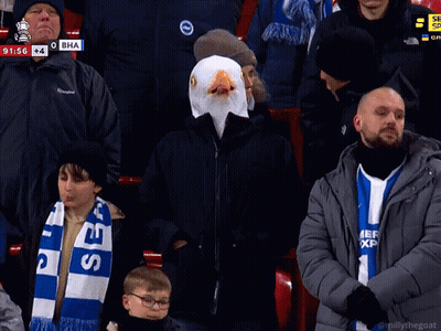 Man In Eagle Mask Sitting In Crowd GIF