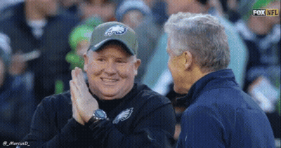 Man In Eagles Hat Talking On Football Field GIF