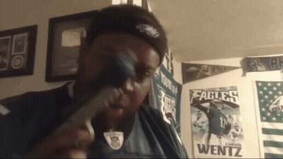 Man In Eagles Shirt Holding Hammer GIF