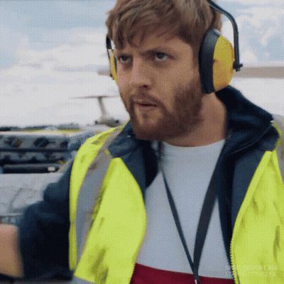 Man In Ear Muffs Yellow Vest Near Airplane GIF