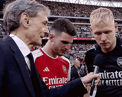 Man In Emirates Shirt Interviewed By Two Men GIF