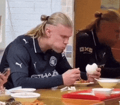 Man In Etihad Shirt At Table With Bowls Of Food GIF