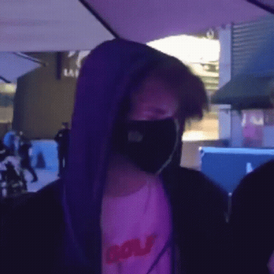 Man In Face Mask And Purple Hoodie Under Umbrella GIF