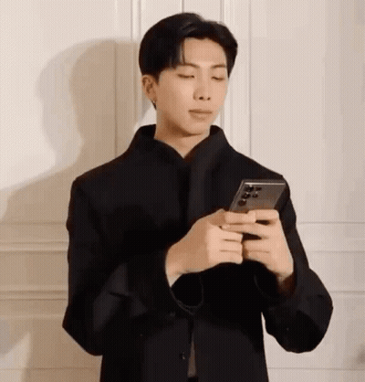 Man In Face Mask Looking At Phone GIF