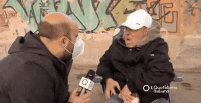 Man In Face Mask Talking To Man In Wheelchair GIF