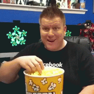 Man In Facebook Shirt Eating Popcorn GIF
