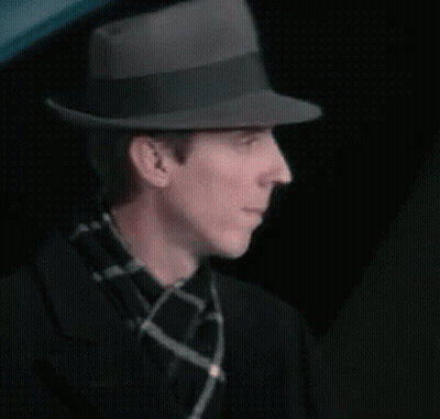 Man In Fedora And Plaid Scarf Adjusting Hat GIF