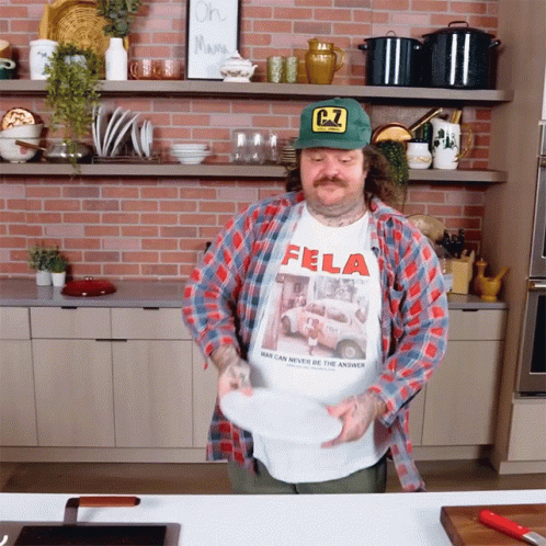 Man In Fela Shirt Holding Plate GIF