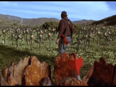 Man In Field With Red Arrow Pointing To Rock GIF