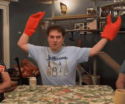 Man In Figlicine Shirt Sitting At Table GIF