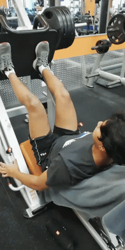 Man In Fila Shirt Doing Leg Presses GIF