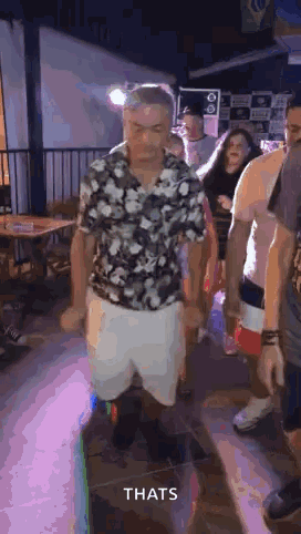 Man In Floral Shirt And White Shorts Dancing In Crowd GIF