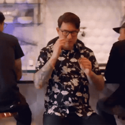Man In Floral Shirt Eating Sandwich At Bar GIF