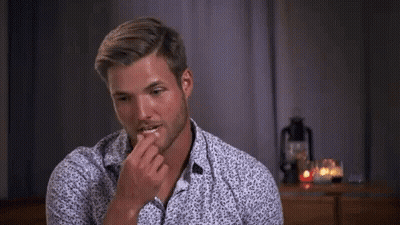Man In Floral Shirt Sitting At Table With Candles GIF