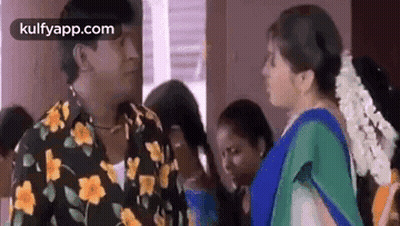 Man In Floral Shirt Talking To Woman In Blue Sari GIF