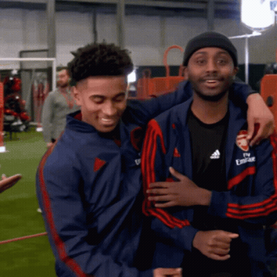 Man In Fly Emirates Jacket Hugging Another Man GIF