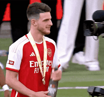 Man In Fly Emirates Jersey Holding Medal GIF