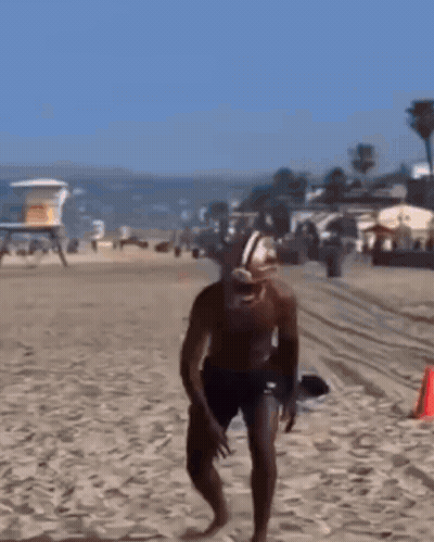 Man In Football Helmet Running On Beach GIF