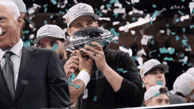 Man In Ford Champions Hat Holding Trophy In Mouth GIF