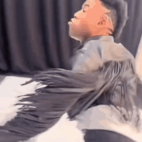 Man In Fringed Jacket Sitting On Bed GIF
