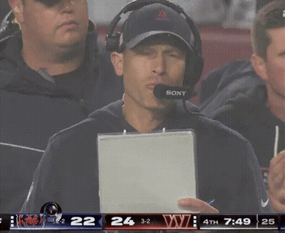 Man In Front Of Blue Wall With Rocket Mortgage GIF