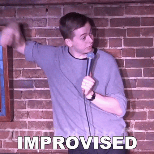 Man In Front Of Brick Wall Holding Microphone With Improvised GIF