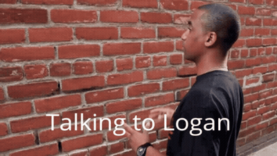 Man In Front Of Brick Wall Saying Talking To Logan GIF