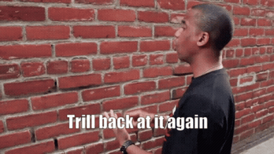 Man In Front Of Brick Wall Saying Trill Back At It Again GIF