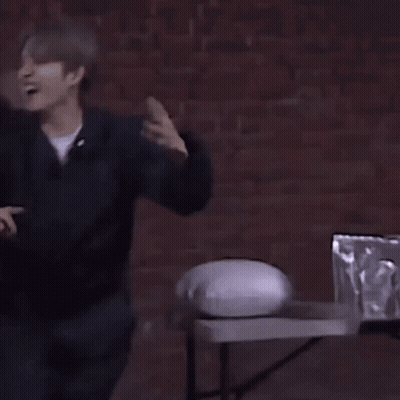 Man In Front Of Brick Wall With Table And Pillow GIF