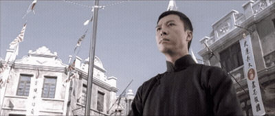 Man In Front Of Building With Chinese Writing GIF