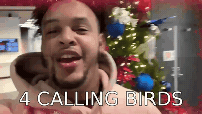 Man In Front Of Christmas Tree Saying 4 Calling Birds GIF