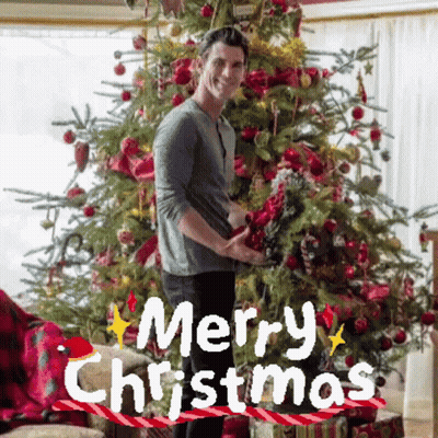 Man In Front Of Christmas Tree With Merry Christmas GIF
