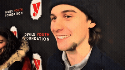 Man In Front Of Devils Youth Foundation Sign GIF