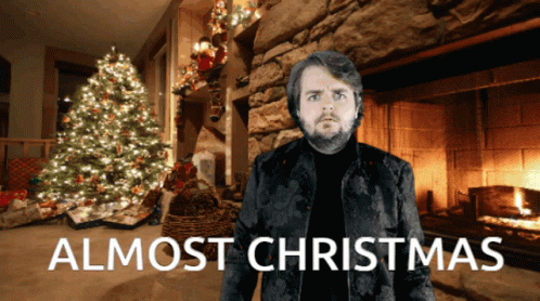 Man In Front Of Fireplace With Words Almost Christmas GIF