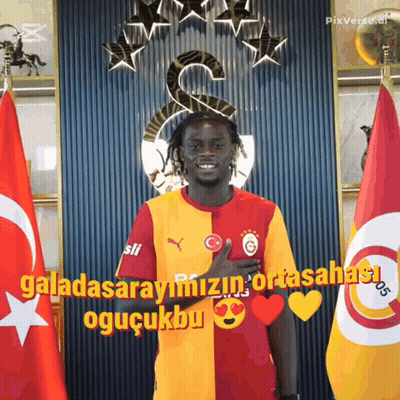 Man In Front Of Flags Saying Galatasarayimizin Ortasahasi GIF
