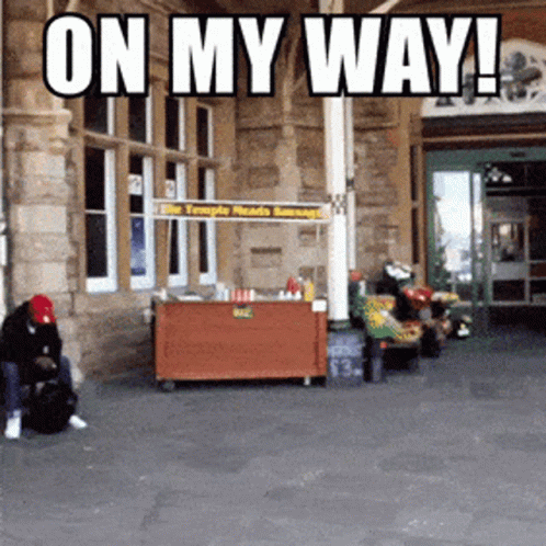 Man In Front Of Food Stand Saying On My Way GIF