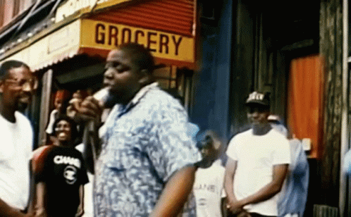 Man In Front Of Grocery Store Holding Microphone GIF