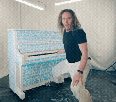 Man In Front Of Piano Covered In Writing GIF