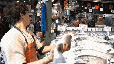 Man In Front Of Place Fish Market Sign GIF