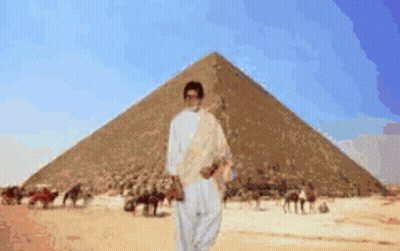 Man In Front Of Pyramid In Desert GIF